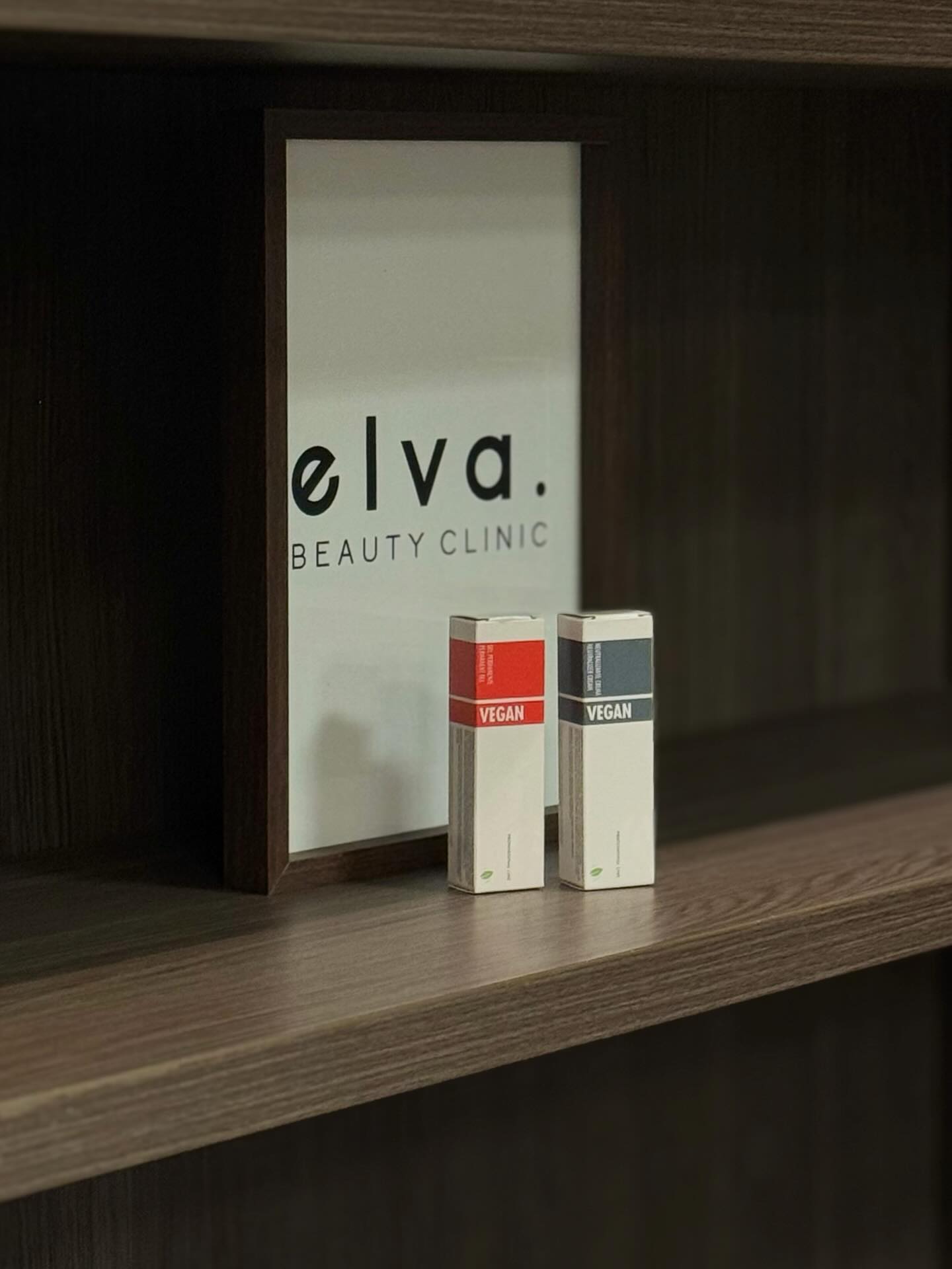 Het Elva Beauty Clinic bord op een houten plank in de salon